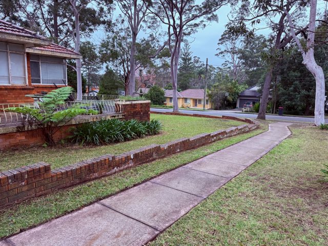 Edged footpath curving along a brick garden wall